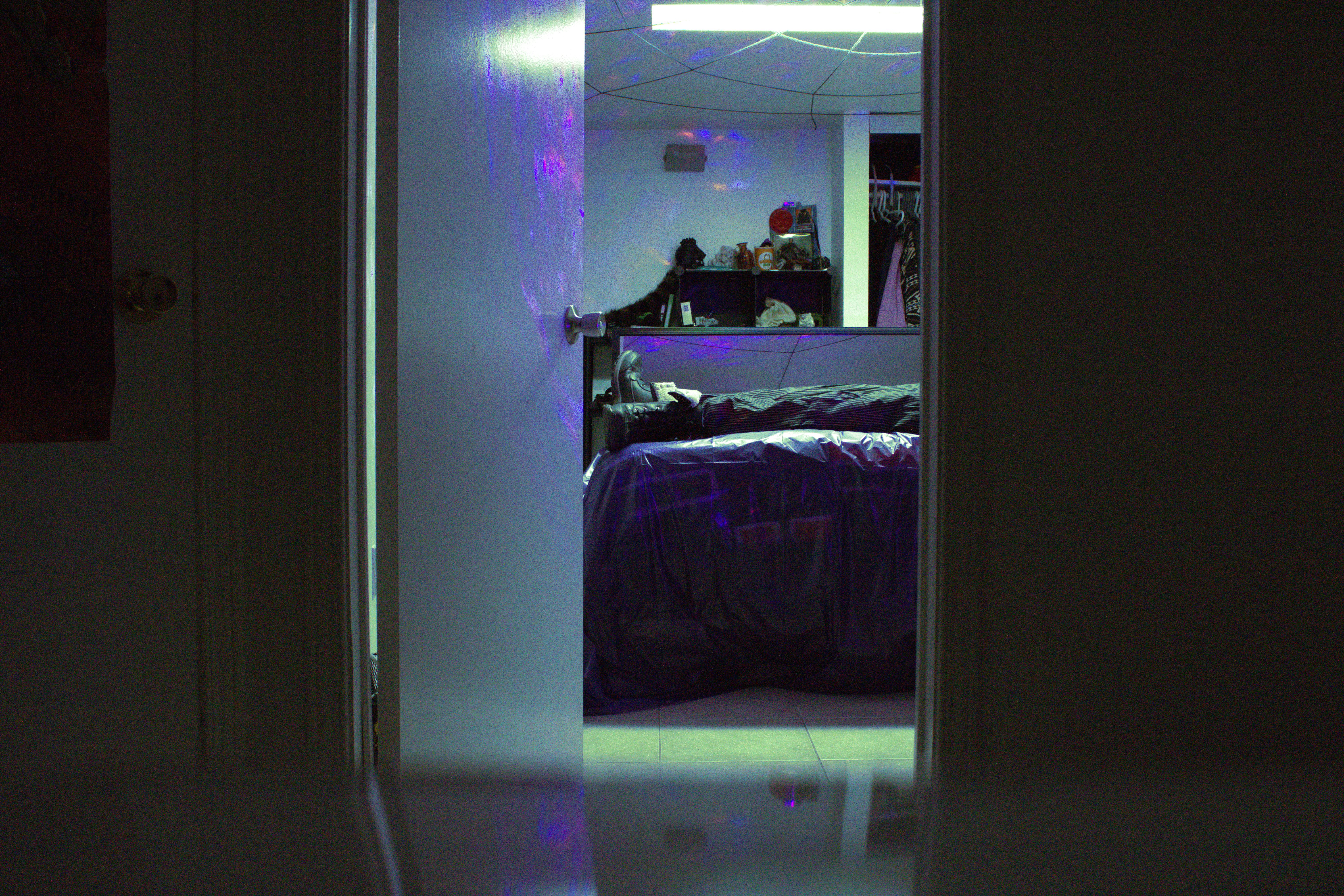 A figure with only its legs visible seen through a doorway