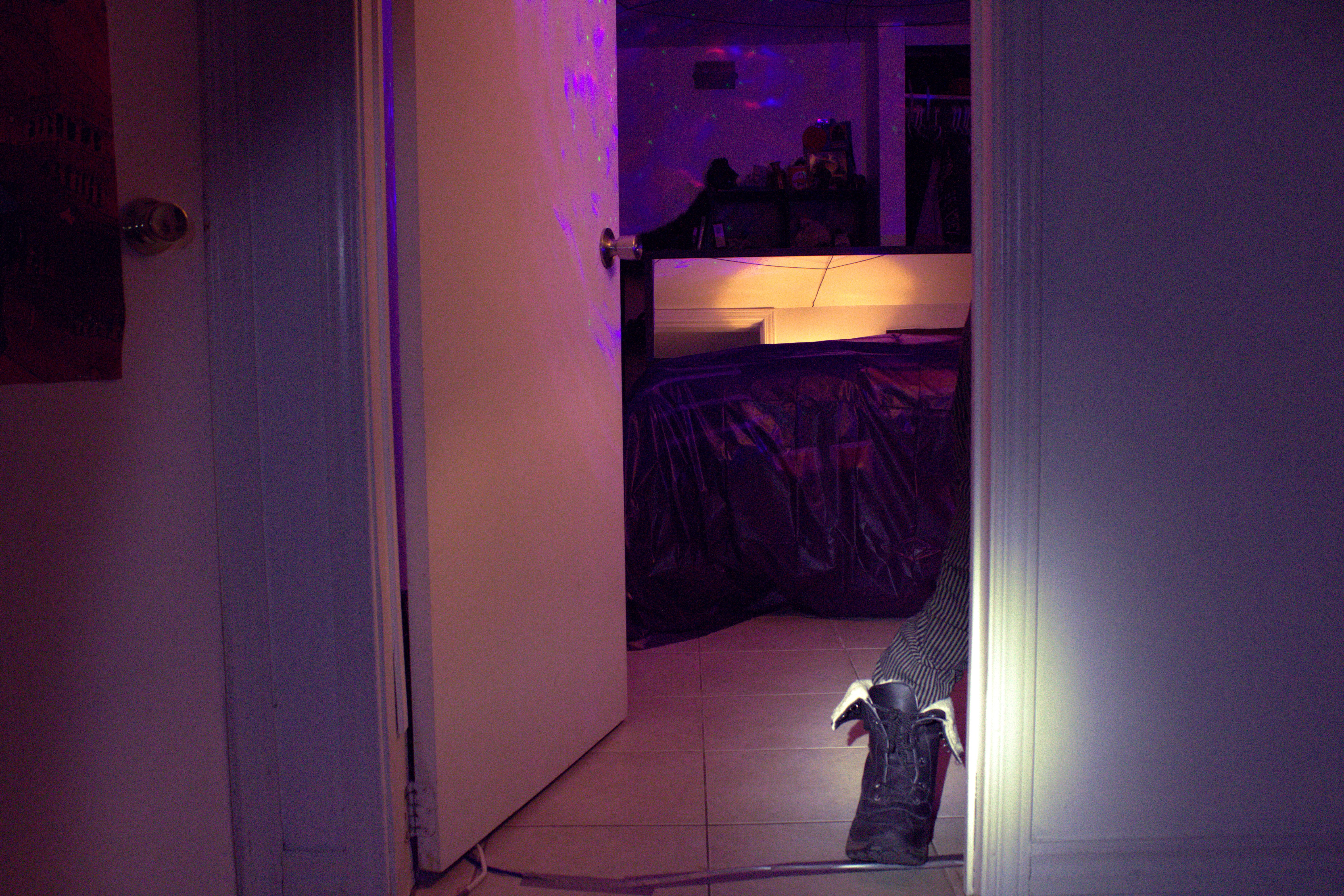 A figure with only its foot visible seen through a doorway
